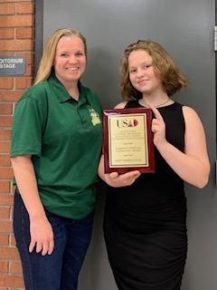 Ashley Stevens, the 2024 Roberts/Caperton Inspiration Award winner, poses with her coach, Megan Kinder Smith, holding a USAD award plaque.